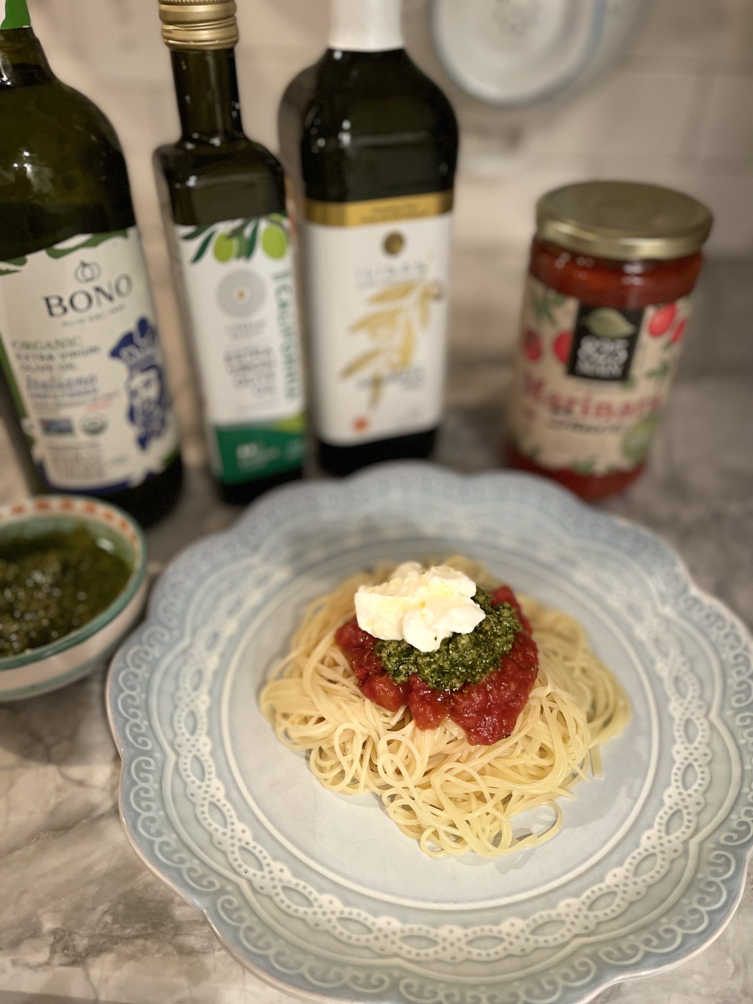 a dish of fresh pesto with 825 MAIN Marinara and Ricotta cheese, drizzled with Extra Virgin Olive Oil and served over pasta